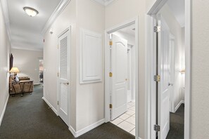 A hallway with white doors, a lamp, and a table with chairs. - Stay Close to the Strip | Pet Friendly Queen Condo (Branson)