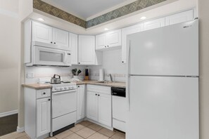 A kitchen with white cabinetry, a microwave, a stove, a dishwasher, and a refrigerator.