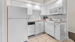 A kitchen with white cabinets, a refrigerator, a microwave, a stove, and a dishwasher. - King Suite | Pet Friendly | Resort Pool & Hot Tub (Branson)