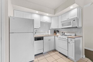A kitchen with white cabinets, a refrigerator, a microwave, a stove, and a dishwasher. - King Suite | Pet Friendly | Resort Pool & Hot Tub (Branson)
