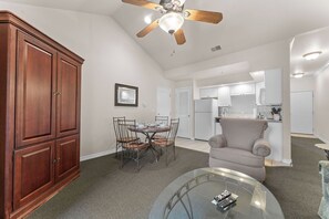A spacious living area with a dining table, chairs, a sofa, a glass coffee table, and a ceiling fan. - King Suite | Pet Friendly | Resort Pool & Hot Tub (Branson)