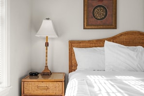A bedroom with a bed, a nightstand with a lamp, and a wall-mounted decorative item. - King Suite | Pet Friendly | Resort Pool & Hot Tub (Branson)