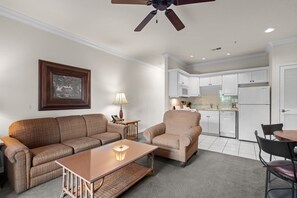 A living room with a sofa, armchair, coffee table, and a ceiling fan. - King Suite | Pet Friendly | Resort Pool & Hot Tub (Branson)