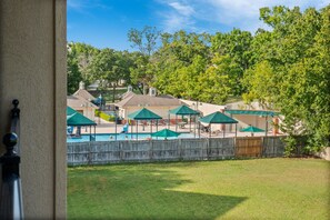 Ein Garten mit Swimmingpool, Sonnenschirmen und Liegestühlen.