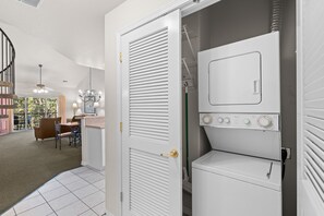 A laundry room with a washer and dryer, a door with a golden handle, and a ceiling fan. - French Quarter Resort | 2BR + Loft | Sleeps 8 (Branson)