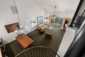 Ein geräumiger Wohnbereich mit Esstisch, Sofas und einer Treppe.