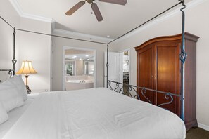 Ein Schlafzimmer mit einem Himmelbett, einem Holzschrank und einem Deckenventilator.