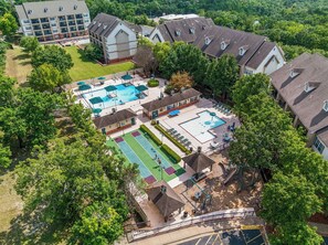 A residential area with multiple buildings, a swimming pool, tennis courts, and a playground. - Family Getaway | 2BR + Loft Near the Branson Strip (Branson)