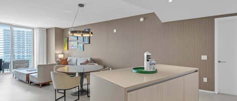 Un interior moderno con comedor, sofá e isla de cocina con dispensador de agua.