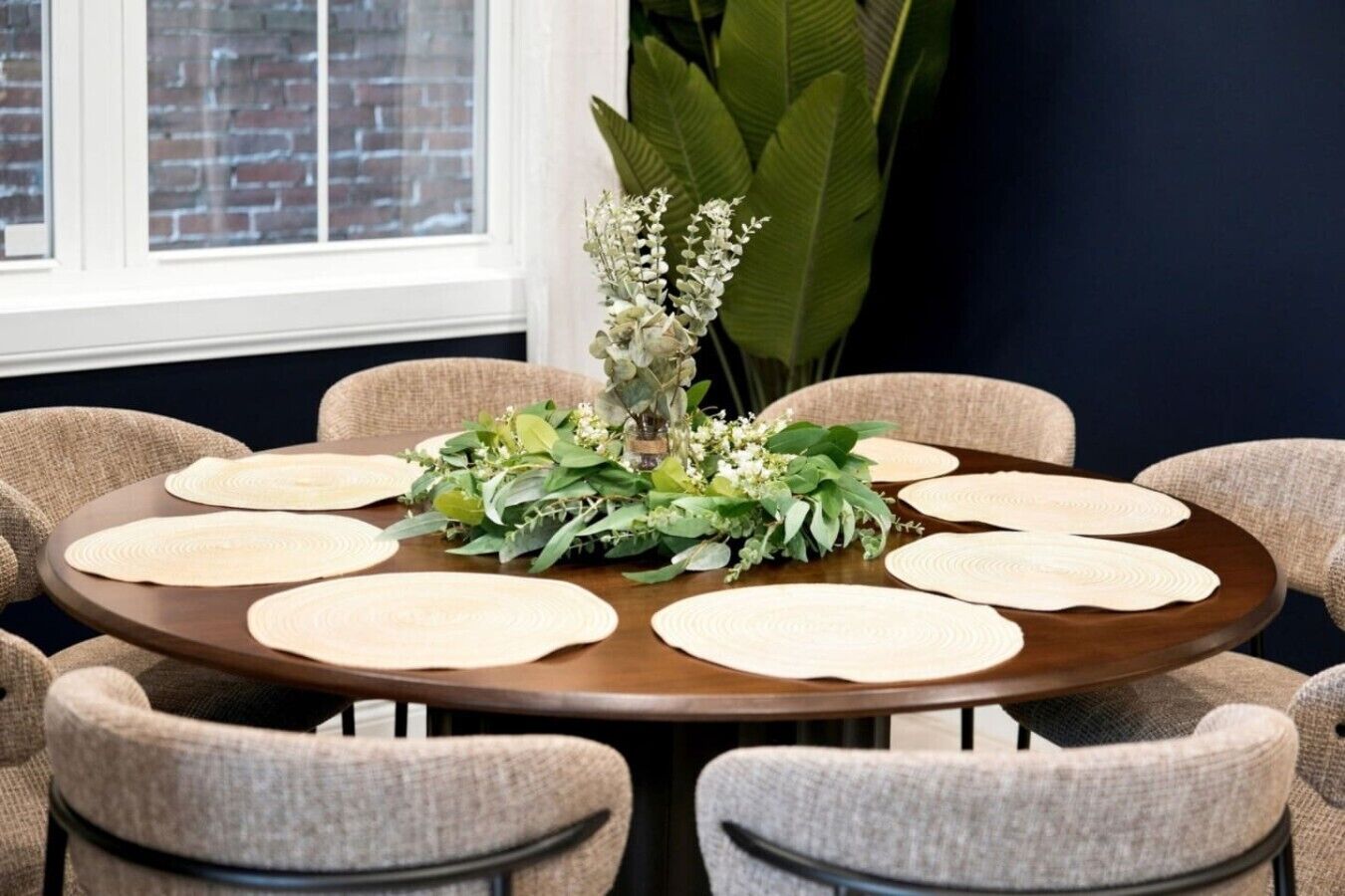Una mesa redonda con un centro de mesa floral rodeado de seis sillas.