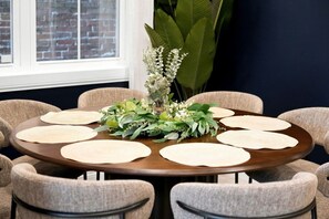 A round table with a floral centerpiece surrounded by six chairs.
