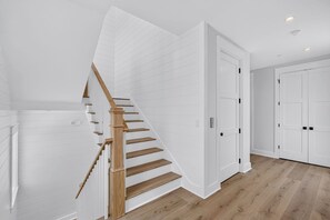 Ein modernes Interieur mit einer Holztreppe, weißen Wänden und einem Holzboden.