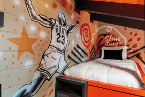 A bedroom with a bed, a wall mural of a basketball player, and a sign that says 'Slap Dunk.' - Luxe Themed Cabin | Theater | Hot Tub | Mtn Views | Sleeps 18+ (Pigeon Forge)