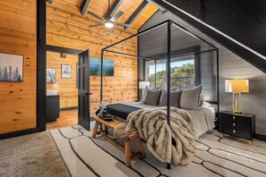 Un dormitorio con cama con dosel, techo de madera y vistas al exterior.