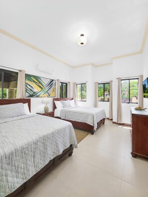 A hotel room with two beds, a wooden dresser, and large windows with curtains. - Spacious 12 Bedrooms Villa for Large Groups in St Ann, Jamaica (Saint Ann's Bay)
