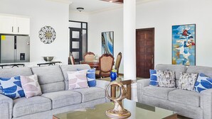 A spacious living room with two grey sofas, a glass coffee table, and a white rug. - Spacious 12 Bedrooms Villa for Large Groups in St Ann, Jamaica (Saint Ann's Bay)