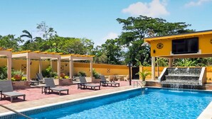 A swimming pool with lounge chairs and a waterfall feature. - Spacious 12 Bedrooms Villa for Large Groups in St Ann, Jamaica (Saint Ann's Bay)