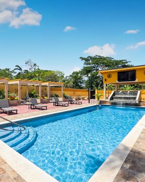 A swimming pool with lounge chairs and a waterfall feature. - Spacious 12 Bedrooms Villa for Large Groups in St Ann, Jamaica (Saint Ann's Bay)