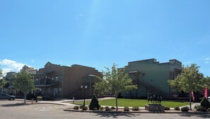 A building with a green facade and a staircase leading to a second level.