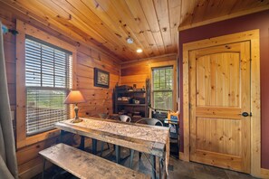 A wooden cabin interior with a dining table, bench, and a door. - Lazy Daze: Views, Pet Friendly, Outdoor Pavilion (Banner Elk)
