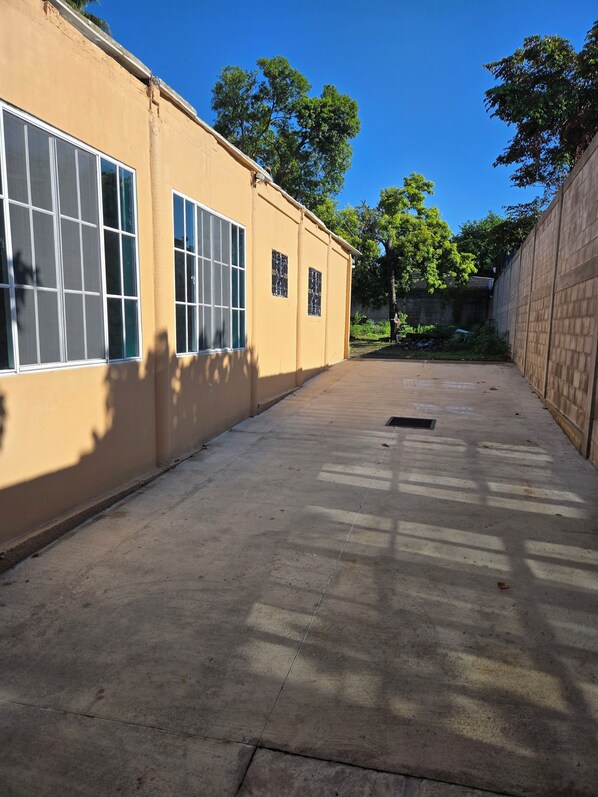 A building with large windows, a concrete floor, and a clear sky.