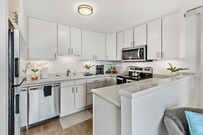 A modern kitchen with white cabinetry, stainless steel appliances, and a central island. - New Listing! My Perfect Stays! (Lahaina)