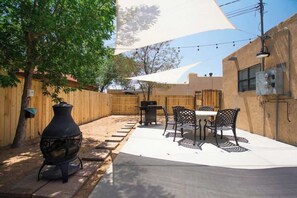 An outdoor patio with a barbecue grill, dining table, and chairs. - Old Town Buffalo+Private Hot Tub+Near Old Town+Pet Friendly! (Albuquerque)