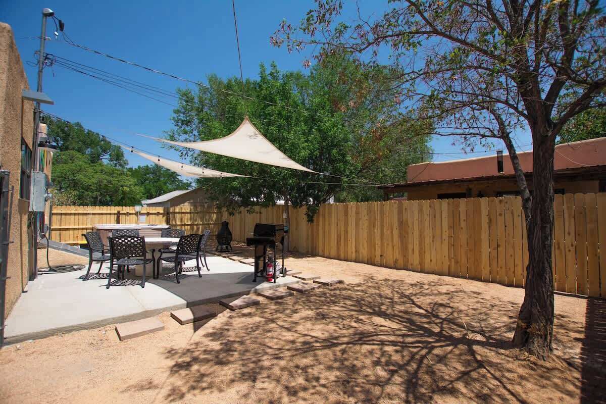 A backyard with a barbecue grill, outdoor table, and chairs.