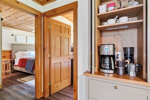 Eine Holztür, die zu einem Schlafzimmer mit einem Bett und einem Nachttisch führt.