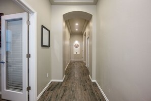 A hallway with a wooden floor, white walls, and a door with blinds. - Welcoming 3-bedroom house with AC in Las Cruces (Las Cruces)