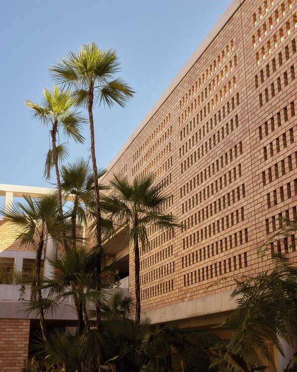 Un edificio con fachada decorativa y palmeras al frente.