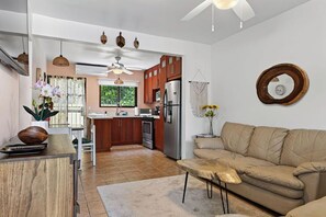 Una cocina moderna con armarios de madera, un refrigerador de acero inoxidable y una zona de comedor con mesa y sillas.