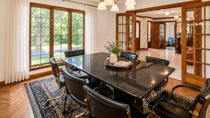 Comedor con una mesa grande, sillas y un candelabro.