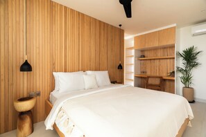 Quarto moderno com parede de ripas de madeira, uma cama grande, mesas de cabeceira e um espaço de escritório embutido.