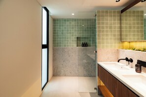 Ein modernes Badezimmer mit einem großen Spiegel, zwei Waschbecken und einer Duschkabine.