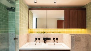 A modern bathroom with a double sink, wooden cabinets, and a mirror above the sink.