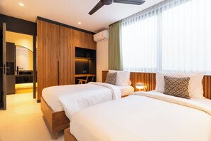 Una habitación de hotel con dos camas, un escritorio y un armario.