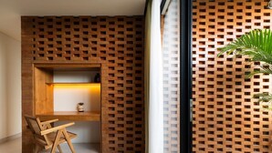 A room with a wooden desk, a chair, and a plant.