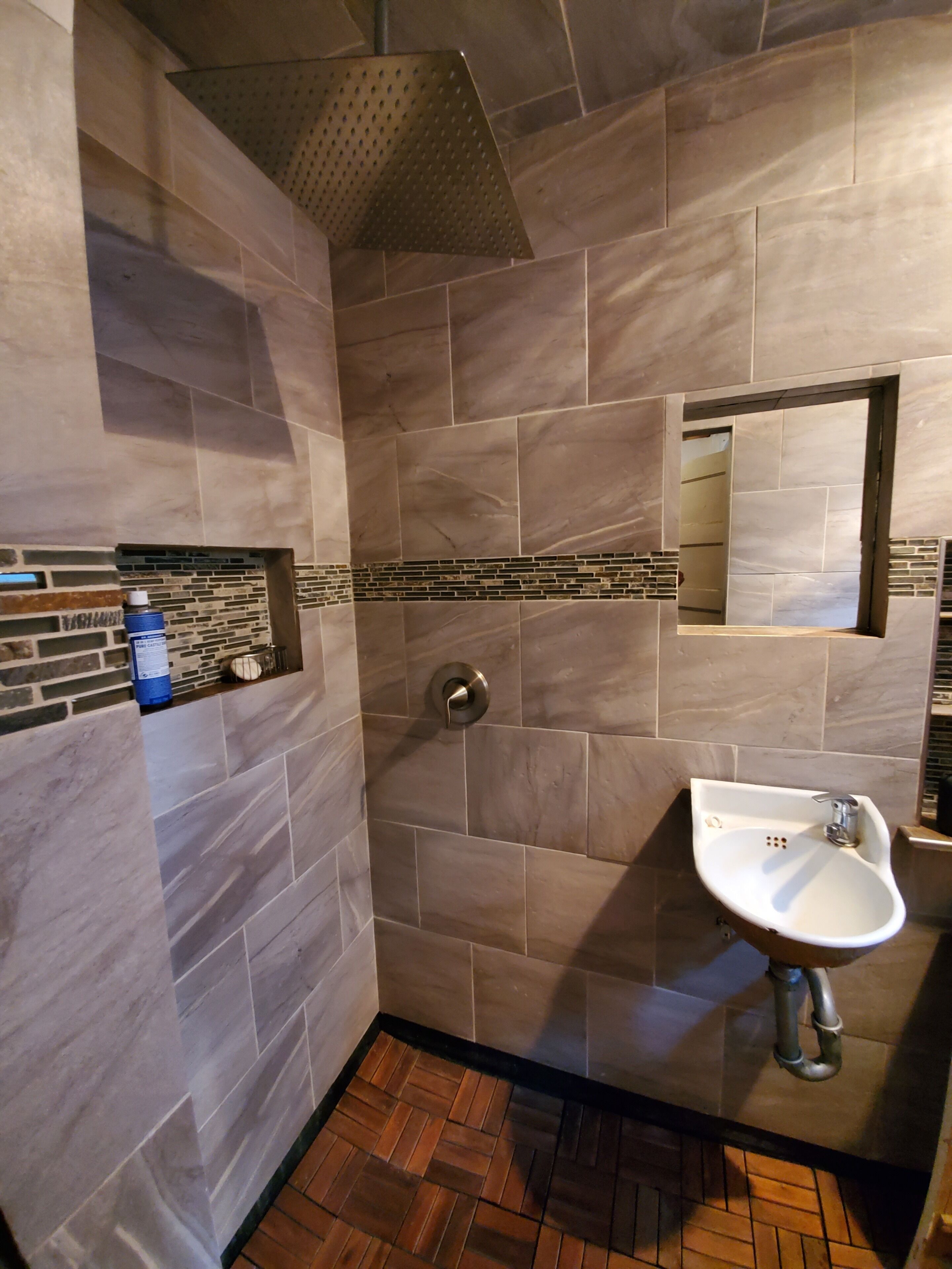 Un baño con ducha, lavabo y espejo.