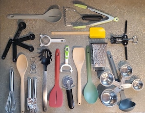 Une variété d’ustensiles et d’outils de cuisine disposés sur une surface.