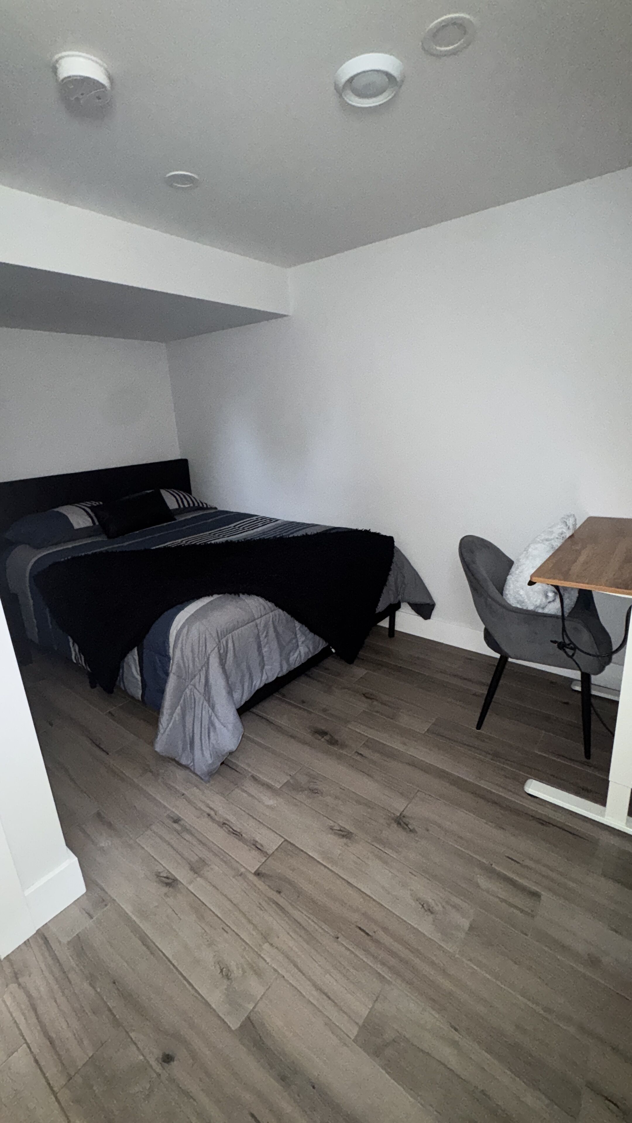 Une chambre à coucher avec un lit, une chaise et un bureau.