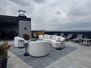 A rooftop patio with a sectional sofa, lounge chairs, and a dining area. - La Cachette du 11e | 2 bedrooms | Parking | Pool | Old Quebec (Quebec)