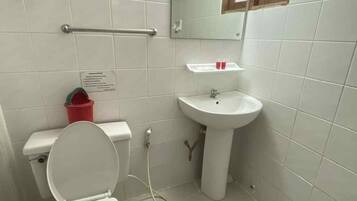 Un bagno con il water, un lavandino e uno specchio.