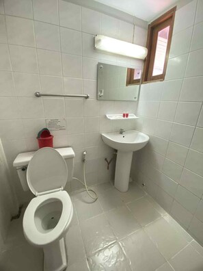 Un baño con inodoro, lavabo y espejo.