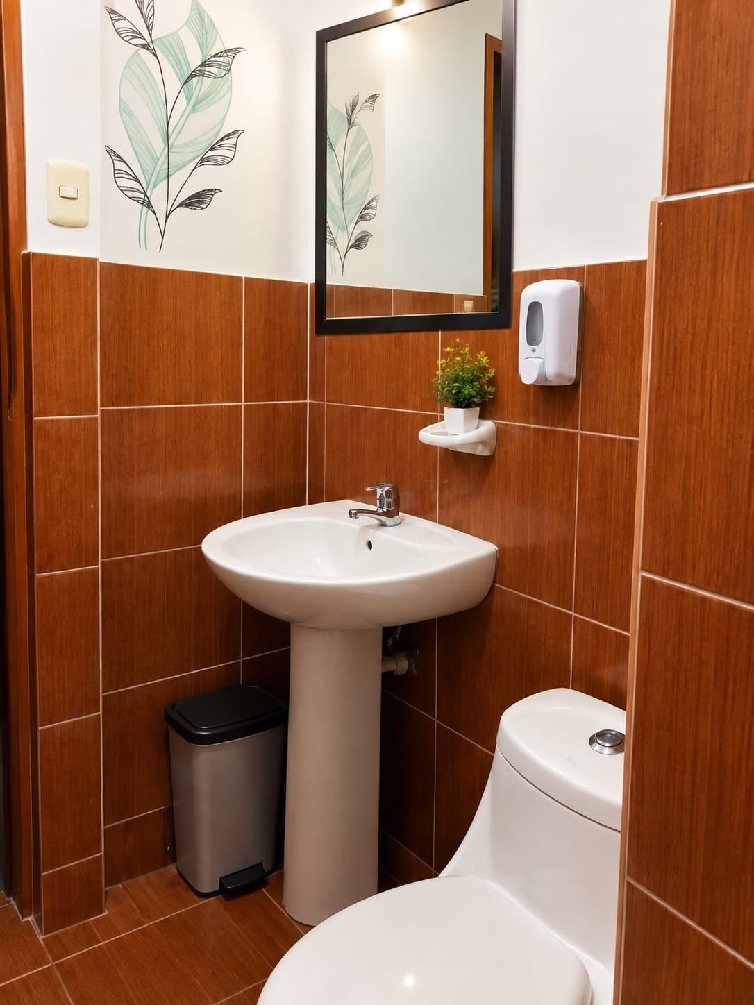 A bathroom with a white sink, a mirror, a hand soap dispenser, and a trash bin.