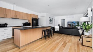 Una cocina moderna con una isla central, armarios de madera y encimera negra.