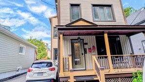 A two-story house with a front porch and a car parked in front. - Luxury Duplex in a Prime Location (Gatineau)