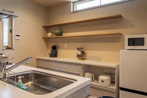 A modern kitchen with a stainless steel sink, a microwave, and a built-in oven. - The leaf (Nishinari Ward)