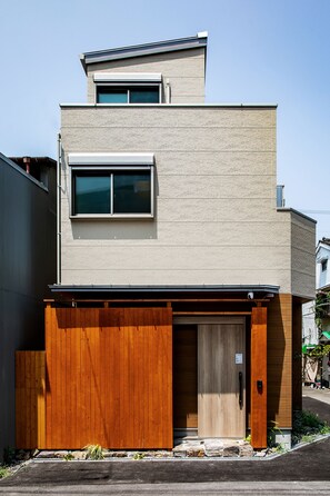 A two-story building with a garage door, a window, and a small balcony. - The leaf (Nishinari Ward)