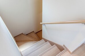 A wooden staircase with a handrail, leading to an upper floor. - The leaf (Nishinari Ward)